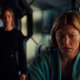 Legends of Tomorrow's Ava Sharpe (Jes Macallan) in a bathrobe sits in the foreground as Sara (Caity Lotz) stands behind her but out of focus.